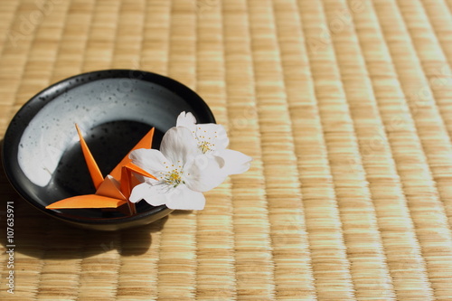Canvas Print Paper crane and cherry blossoms on traditional Japanese Tatami flooring mat