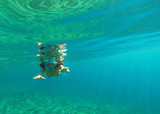 Underwater view of a woman snorkeling in the tropical sea