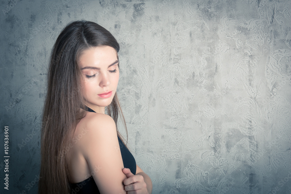 beautiful girl posing in a black evening dress. toned portrait in the studio beautiful girl posing in a black evening dress. toned portrait in the studio