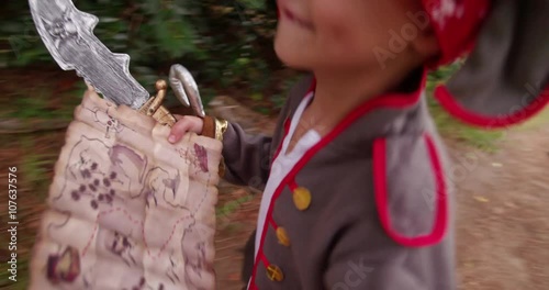 Boy dressing up as pirate looking for treasure chest on reading map photo