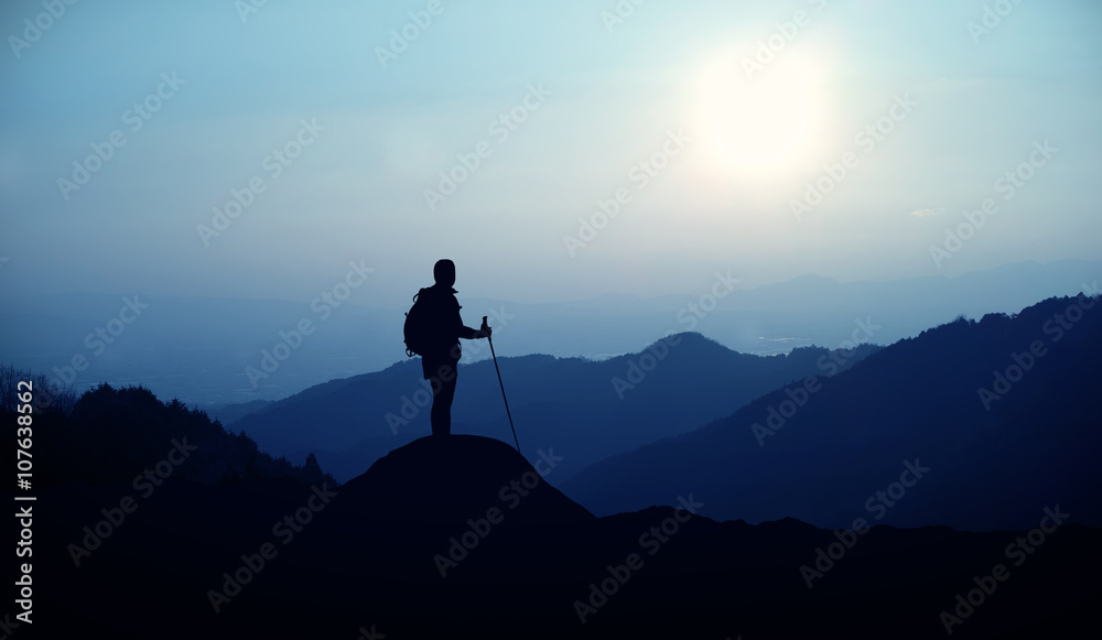 Hiker with backpack standing on the hill