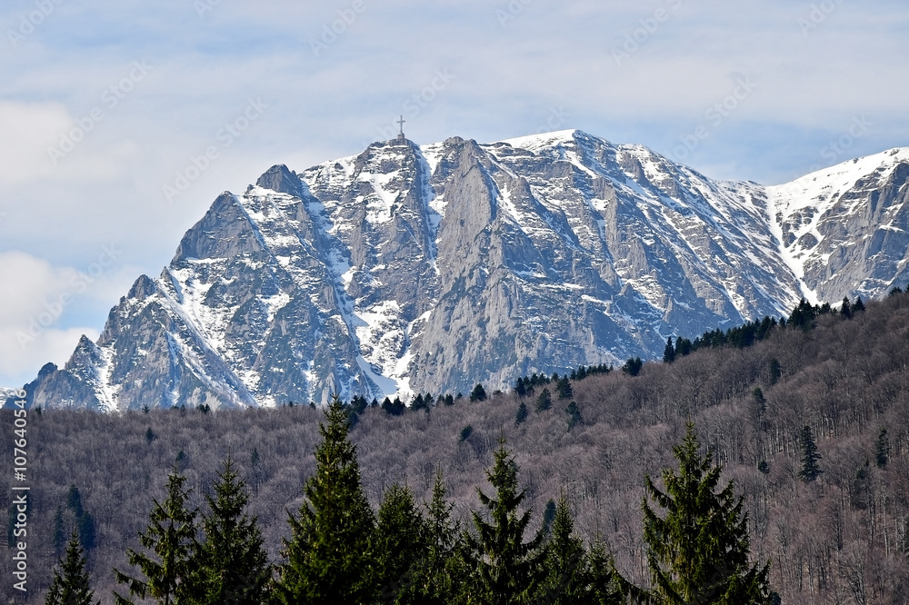 Bucegi mountains in winter with the Heroes Cross on Caraiman Pea