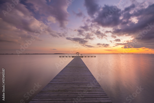 Fototapeta Naklejka Na Ścianę i Meble -  Pomost na jeziorze po zachodzie słońca