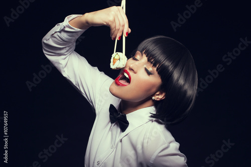 Woman in waiter style eat sushi