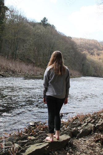Trauriges Mädchen schaut voller Sehnsucht auf den Fluss