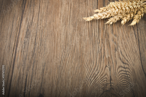 Wheat spikes on the dark wooden board