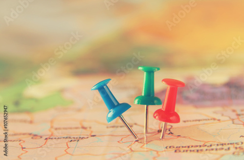 pins attached to map, showing location or travel destination . retro style image. selective focus. 