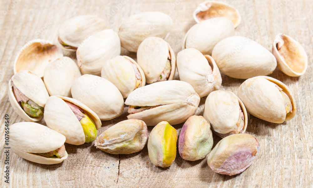 Pistachios on wood background.