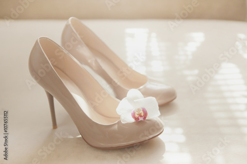 Beige wedding patent leather shoes on light background with orhi