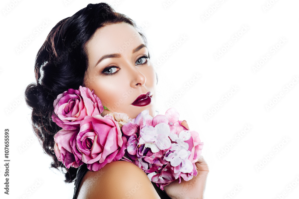 beautiful girl with flowers pink roses in hands. with manicure, hair and makeup in the studio on a white background
