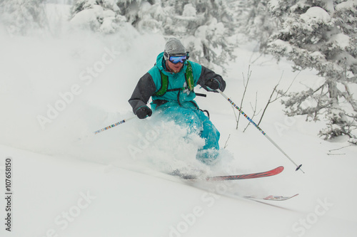 Extreme downhill skier on the snow in forest.