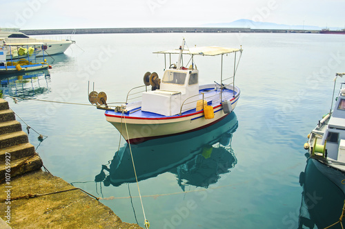 the reflection of a fishing boat on sea