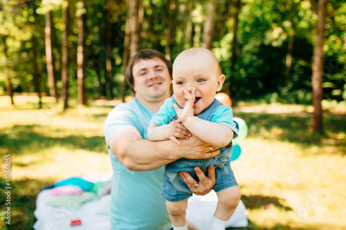 Young father with little son having fun outdoors at picnic in the park