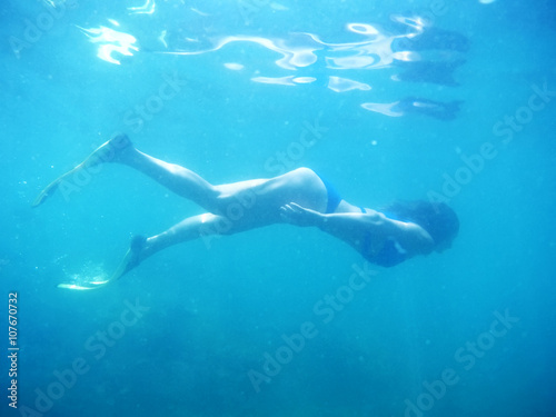 Underwater shot of the woman moving on the breath hold in the depth