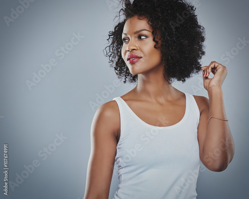 Smiling flirting woman in white top, grey background