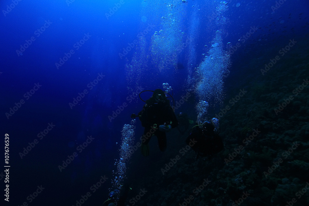 group of divers underwater on a coral reef group of divers underwater on a coral reef