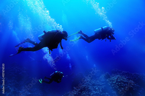 group of divers underwater on a coral reef