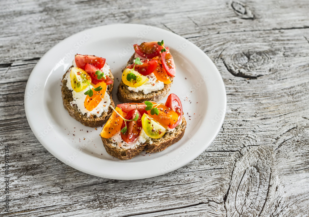 Tomato and cheese bruschetta on a white plate on rustic light wooden board. Healthy breakfast, snack or appetizer with wine Tomato and cheese bruschetta on a white plate on rustic light wooden board. Healthy breakfast, snack or appetizer with wine