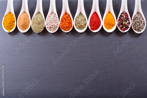 Fototapeta Naklejka Na Ścianę i Meble -  various spices in ceramic spoons on dark background