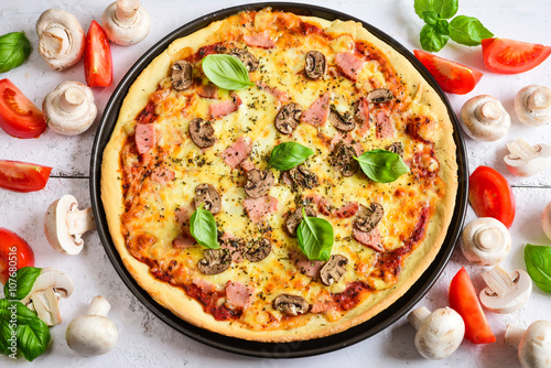 Delicious pizza with mushrooms, ham and basil.