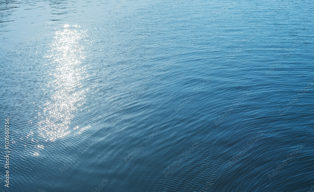 Obraz premium blue water with sun reflections as background
