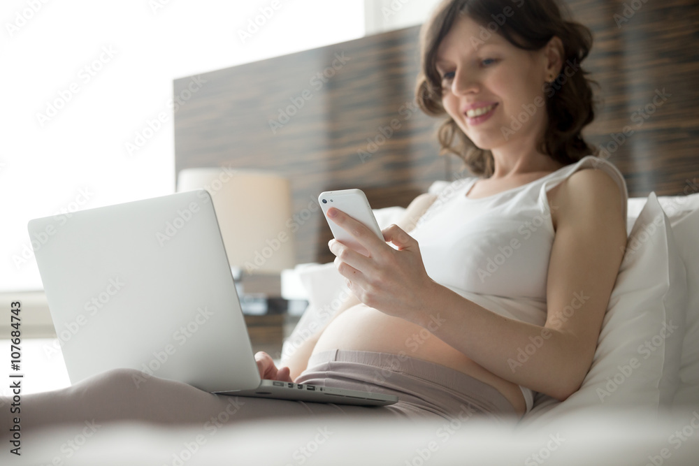 Fototapeta premium Pregnant woman using electronic devices