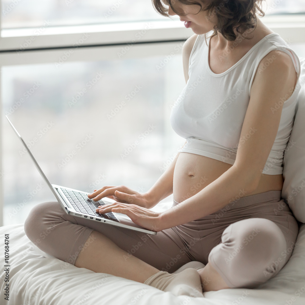 Naklejka premium Pregnant woman working on computer at home