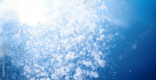 Winter background. Falling snow in blue sky