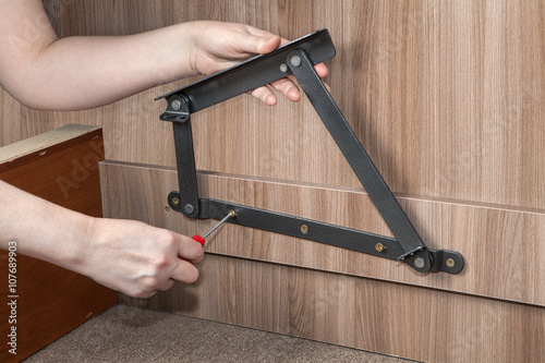 Photography Assembling furniture, hands screwed lift up bed adjustable metal hinge