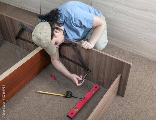 Women putting together self assembly furniture. photo