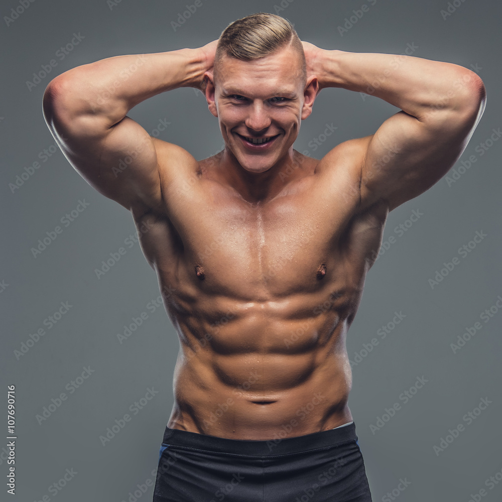 Shirtless muscular man isolated on a grey background. Shirtless muscular man isolated on a grey background.
