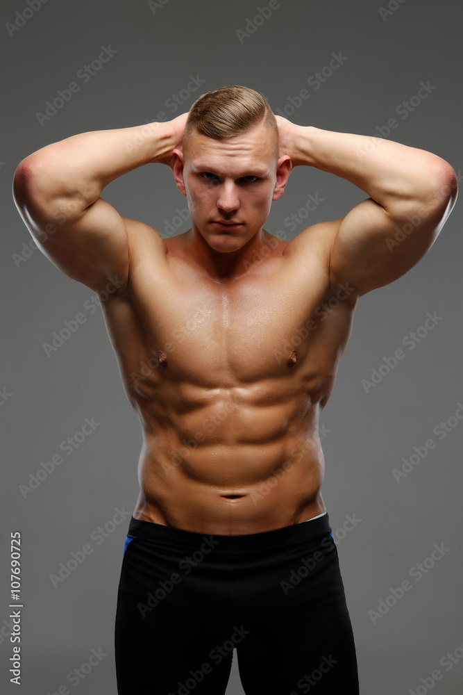Shirtless muscular man isolated on a grey background.