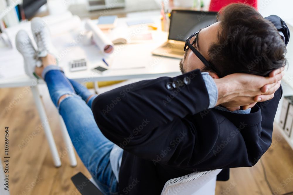 Handsome young businessman relaxing one moment in the office. Handsome young businessman relaxing one moment in the office.