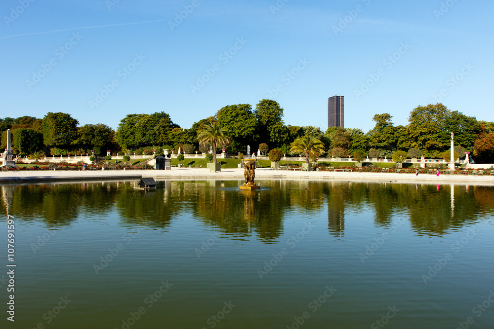 Color DSLR stock image of pond in Luxembourg Gardens with the Montparnesse Tower in the background. The Paris, France park is popular with residents and tourists. Horizontal with copy space for text