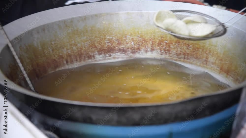Fried Japanese Cracker on boiling oil closeup with unknown man cooking
Fried Japanese Cracker on boiling oil closeup with unknown man cooking