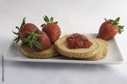 composizione fotografica a colori di frutta fresca fragole e marmellata con fette biscottate per la prima colazione
