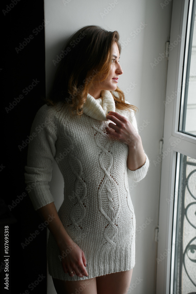 young sexy girl in white sweater near the window foto de Stock | Adobe Stock