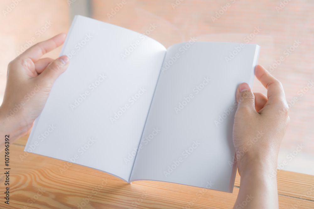 Hands open book on wood table Hands open book on wood table