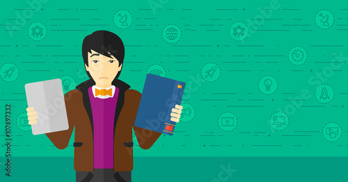 Man choosing between book and tablet computer.