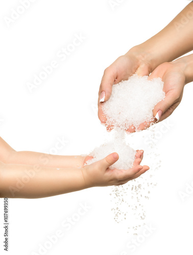 Sea salt crystals in women hand and child hand.