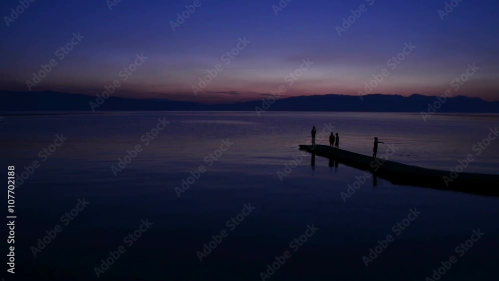People enjoy sunset at calm lake in Ohrid, Macedonia. People enjoy sunset at calm lake in Ohrid, Macedonia.