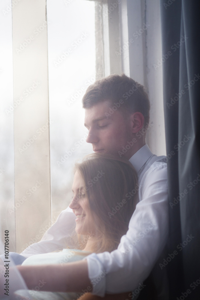 Young couple enjoying themselves on the windowsill Young couple enjoying themselves on the windowsill