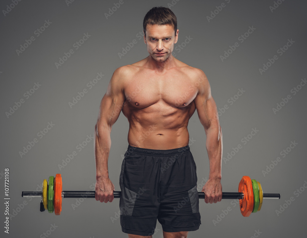 Shirtless middle age man holds colored barbell. Shirtless middle age man holds colored barbell.