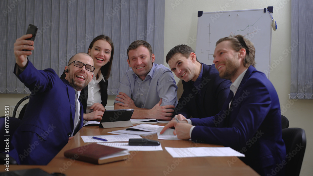 Business people making face while taking selfie in office Business people making face while taking selfie in office