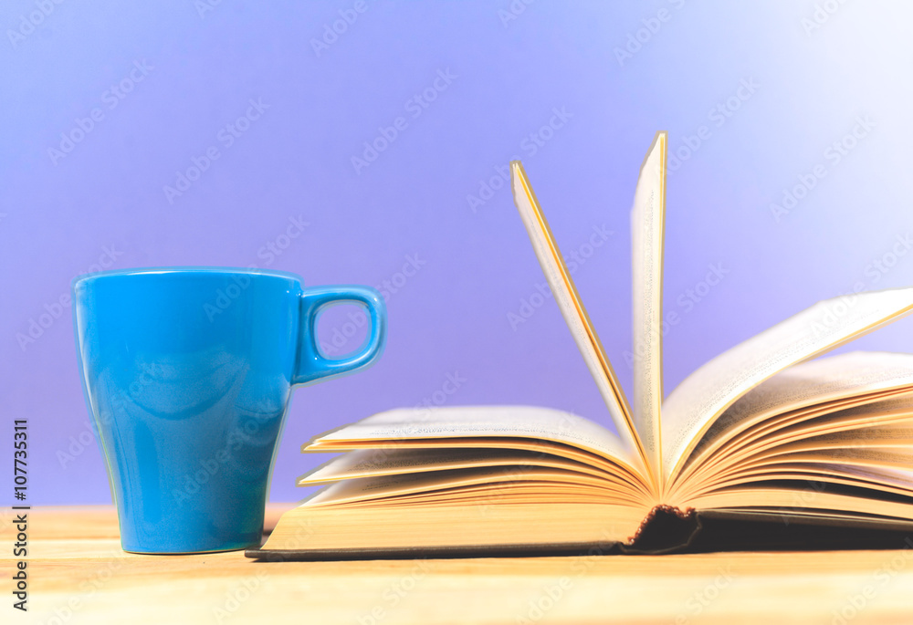 Naklejka premium Color cup of tea with books on table