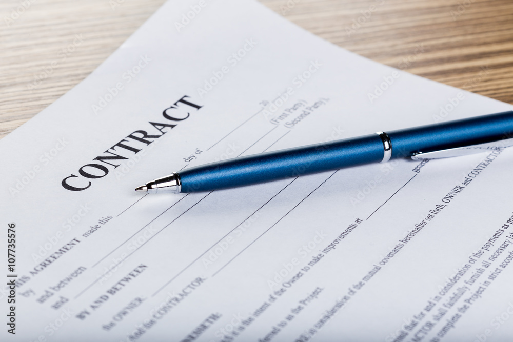 Pen and contract papers on wooden desk Pen and contract papers on wooden desk