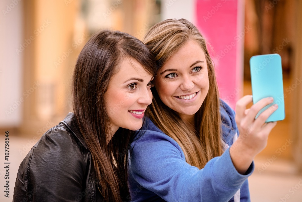 Two beautiful women taking a selfie in shopping mall Two beautiful women taking a selfie in shopping mall