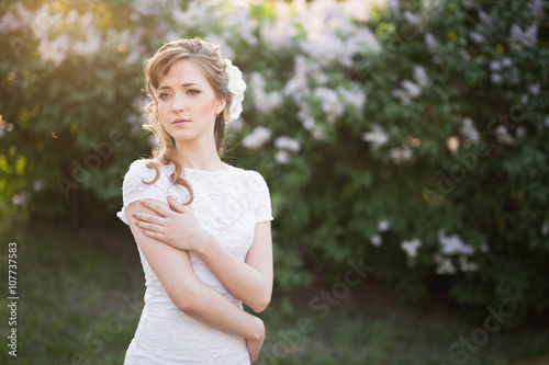 Bride in white dress embracing herself while looking away