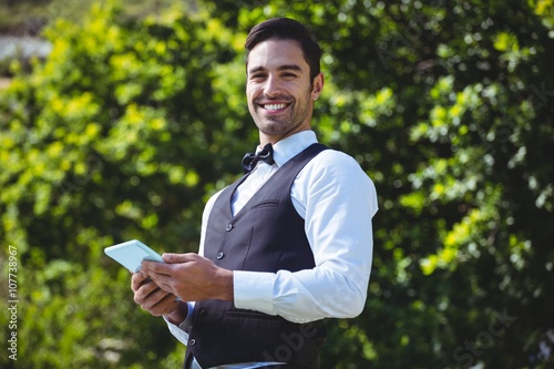 Handsome waiter using tablet computer