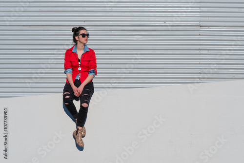 Girl sitting on white wall